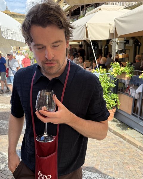 Portrait of Duncan Gammie holding a wine glass at a festival