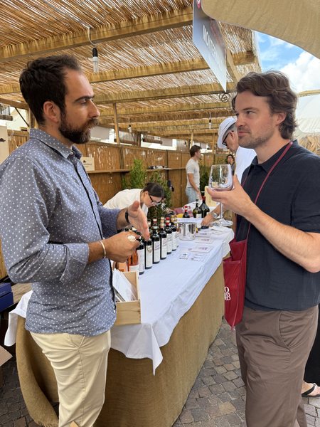 Duncan Gammie tasting at a grower's table under a cane roof